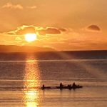 Tralee beach with kayaks at sunset
